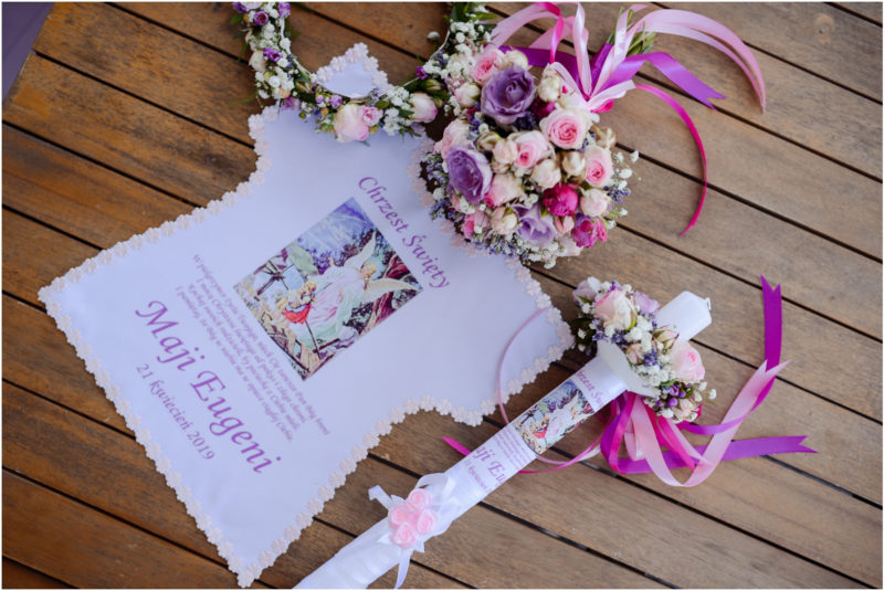 chrzest portret chrzest mała dziewczynka z wiankiem na głowie siedzi pod magnolią