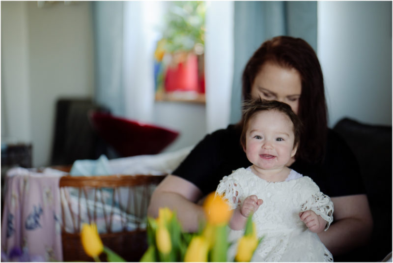 chrzest portret chrzest mała dziewczynka z wiankiem na głowie siedzi pod magnolią