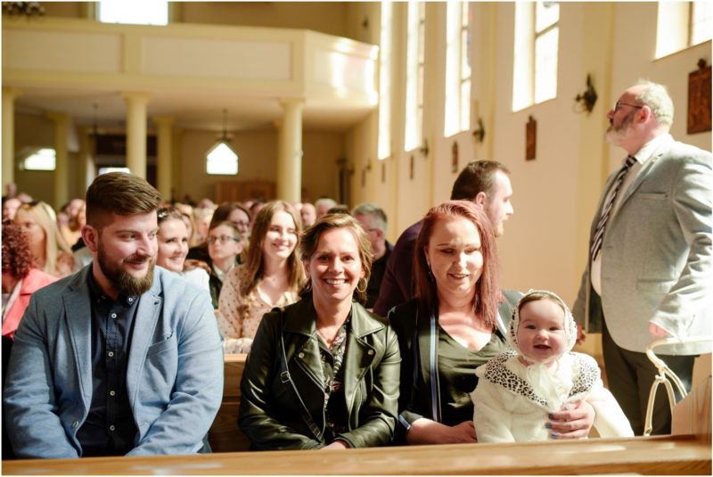 chrzest portret chrzest mała dziewczynka z wiankiem na głowie siedzi pod magnolią