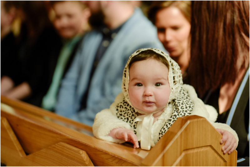 chrzest portret chrzest mała dziewczynka z wiankiem na głowie siedzi pod magnolią