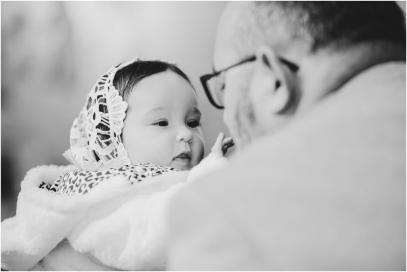 chrzest portret chrzest mała dziewczynka z wiankiem na głowie siedzi pod magnolią