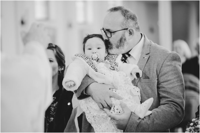 chrzest portret chrzest mała dziewczynka z wiankiem na głowie siedzi pod magnolią