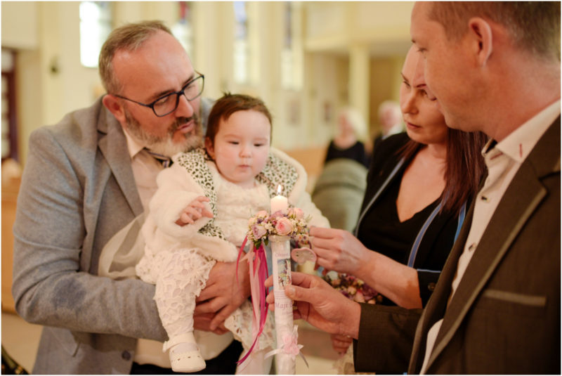 chrzest portret chrzest mała dziewczynka z wiankiem na głowie siedzi pod magnolią