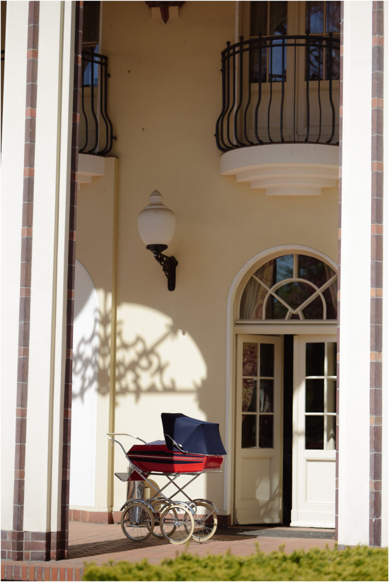 chrzest portret chrzest mała dziewczynka z wiankiem na głowie siedzi pod magnolią