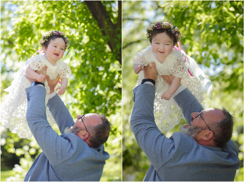 chrzest portret chrzest mała dziewczynka z wiankiem na głowie siedzi pod magnolią
