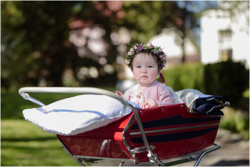 chrzest portret chrzest mała dziewczynka z wiankiem na głowie siedzi pod magnolią