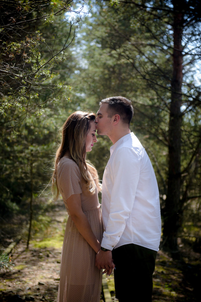 mężczyzna całuje kobietę z rozwianymi włosami