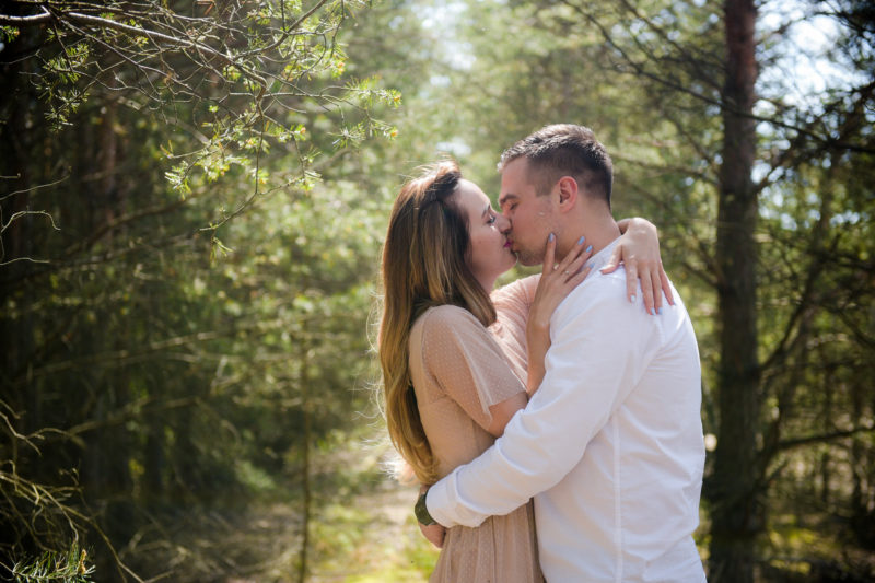 mężczyzna całuje kobietę z rozwianymi włosami