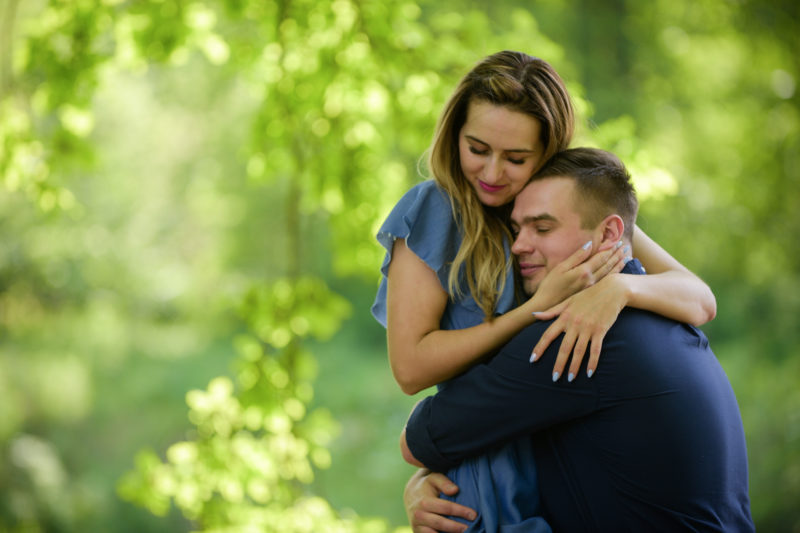 mężczyzna całuje kobietę z rozwianymi włosami