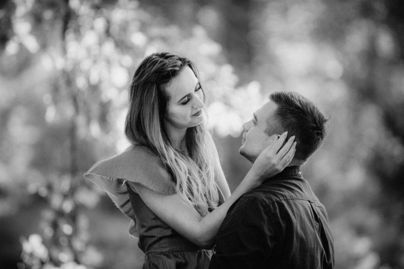 mężczyzna całuje kobietę z rozwianymi włosami