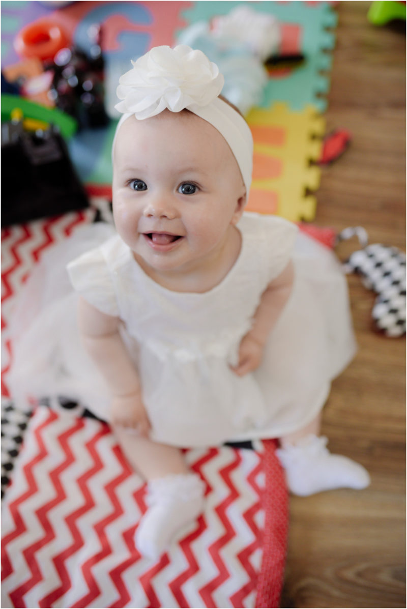 chrzest Wrocław fotografia chrzest Wrocłąw mała dziewczynka siedi na trwaie w parku