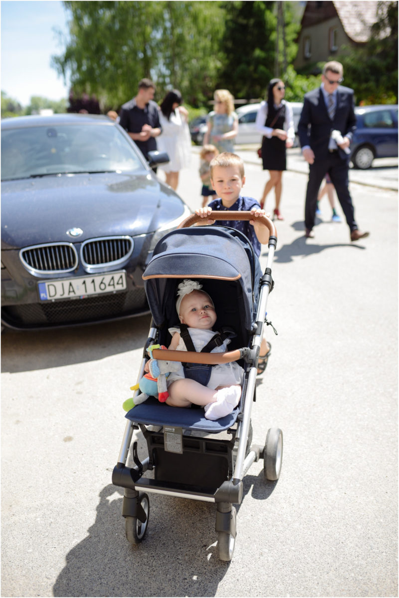 chrzest Wrocław fotografia chrzest Wrocłąw mała dziewczynka siedi na trwaie w parku