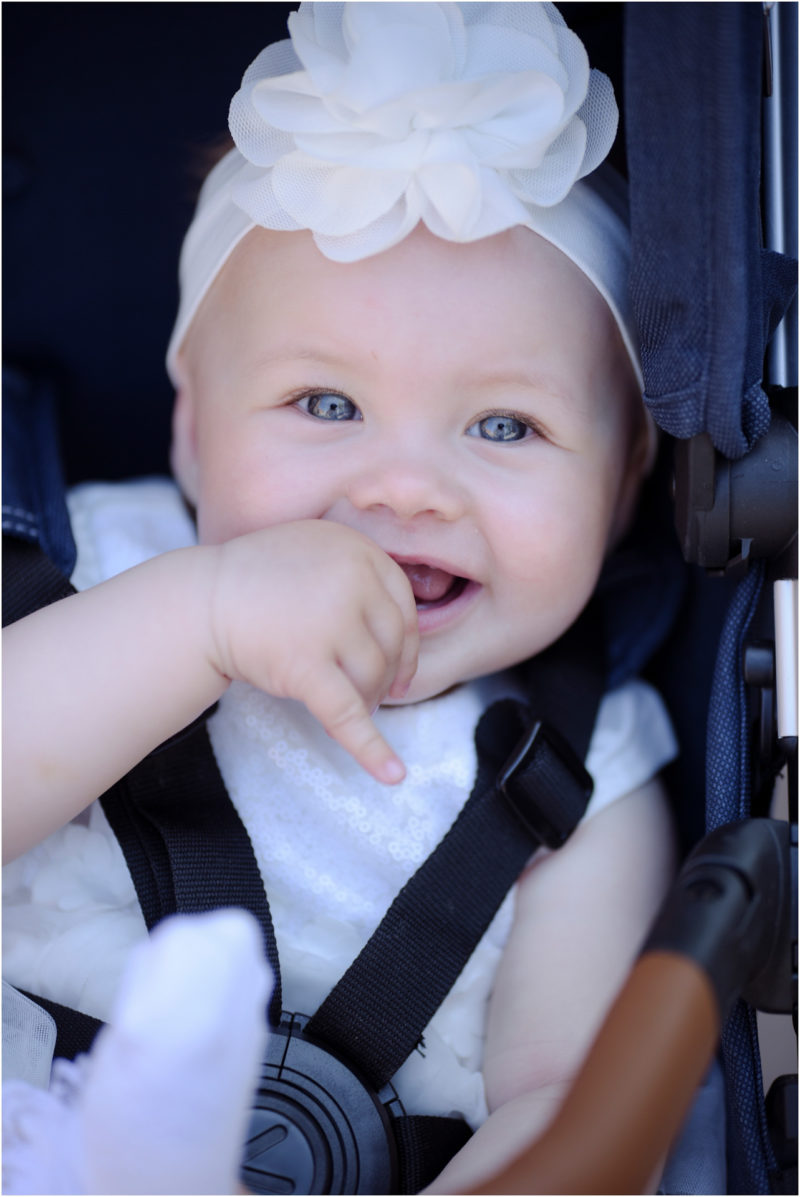 chrzest Wrocław fotografia chrzest Wrocłąw mała dziewczynka siedi na trwaie w parku