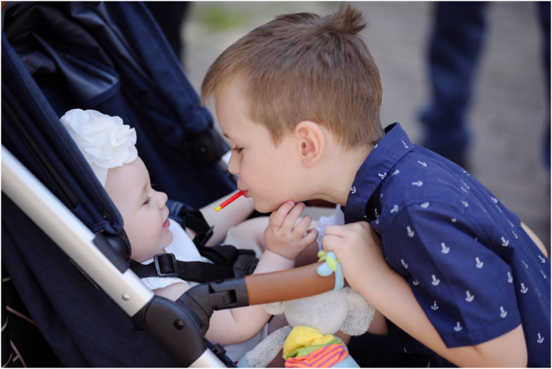 chrzest Wrocław fotografia chrzest Wrocłąw mała dziewczynka siedi na trwaie w parku