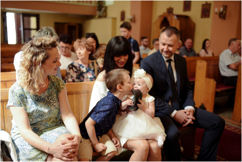 chrzest Wrocław fotografia chrzest Wrocłąw mała dziewczynka siedi na trwaie w parku