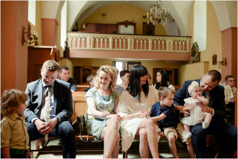 chrzest Wrocław fotografia chrzest Wrocłąw mała dziewczynka siedi na trwaie w parku