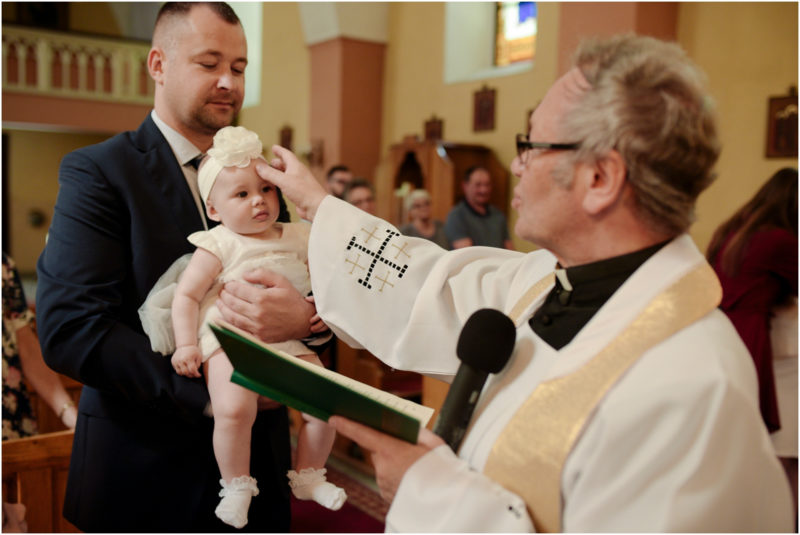 chrzest Wrocław fotografia chrzest Wrocłąw mała dziewczynka siedi na trwaie w parku