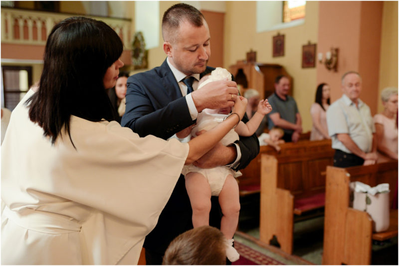 chrzest Wrocław fotografia chrzest Wrocłąw mała dziewczynka siedi na trwaie w parku