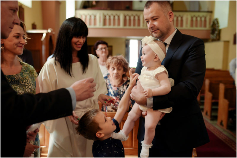 chrzest Wrocław fotografia chrzest Wrocłąw mała dziewczynka siedi na trwaie w parku