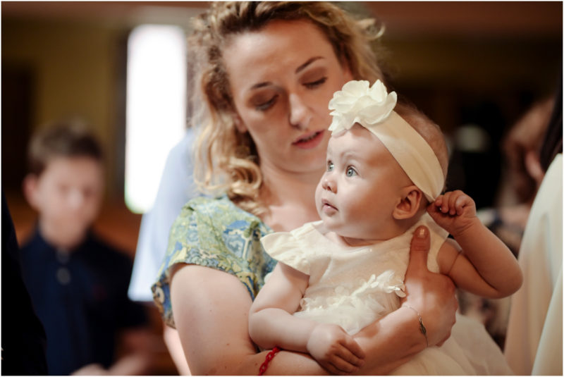 chrzest Wrocław fotografia chrzest Wrocłąw mała dziewczynka siedi na trwaie w parku