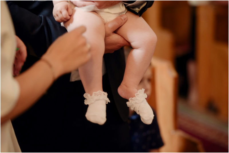 chrzest Wrocław fotografia chrzest Wrocłąw mała dziewczynka siedi na trwaie w parku