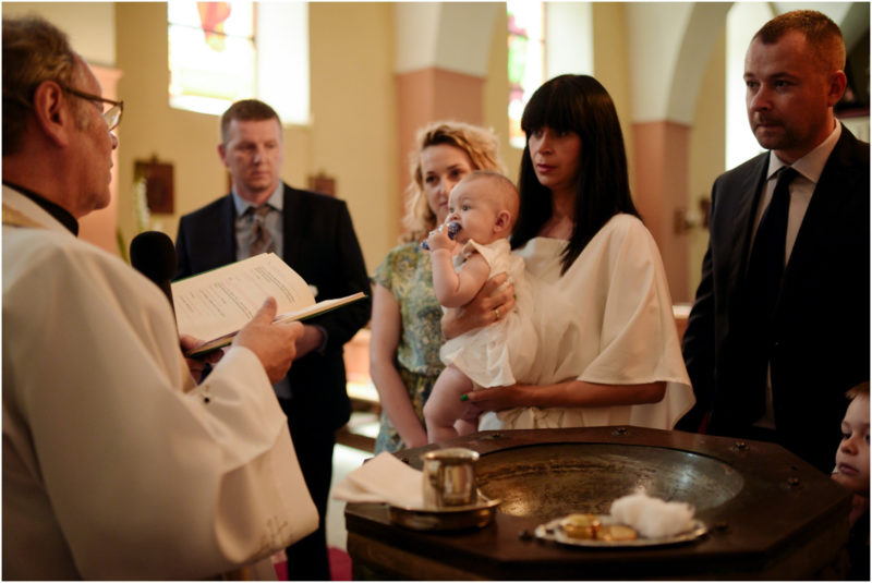 chrzest Wrocław fotografia chrzest Wrocłąw mała dziewczynka siedi na trwaie w parku