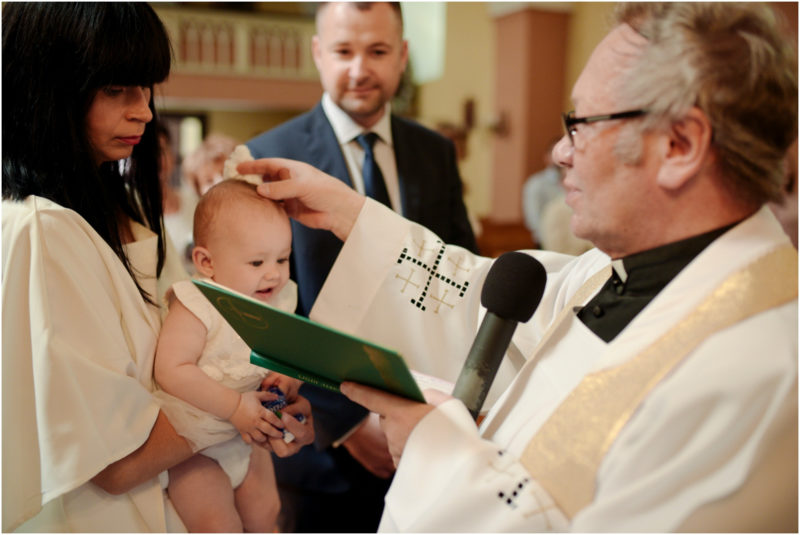 chrzest Wrocław fotografia chrzest Wrocłąw mała dziewczynka siedi na trwaie w parku