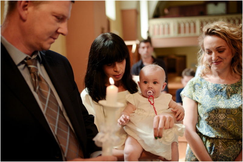 chrzest Wrocław fotografia chrzest Wrocłąw mała dziewczynka siedi na trwaie w parku