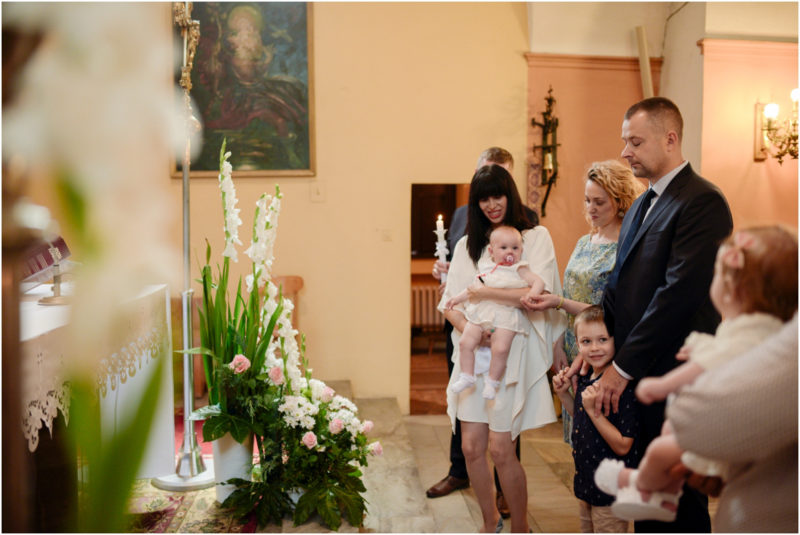 chrzest Wrocław fotografia chrzest Wrocłąw mała dziewczynka siedi na trwaie w parku