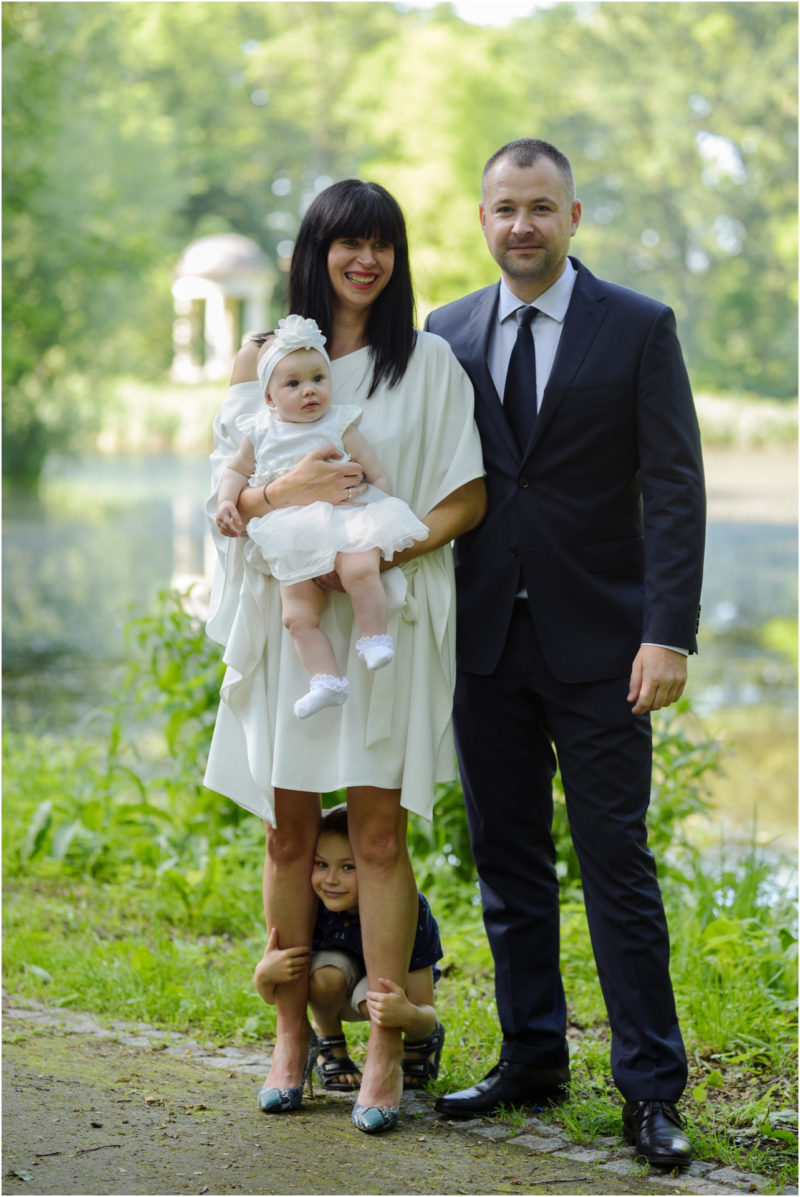 chrzest Wrocław fotografia chrzest Wrocłąw mała dziewczynka siedi na trwaie w parku
