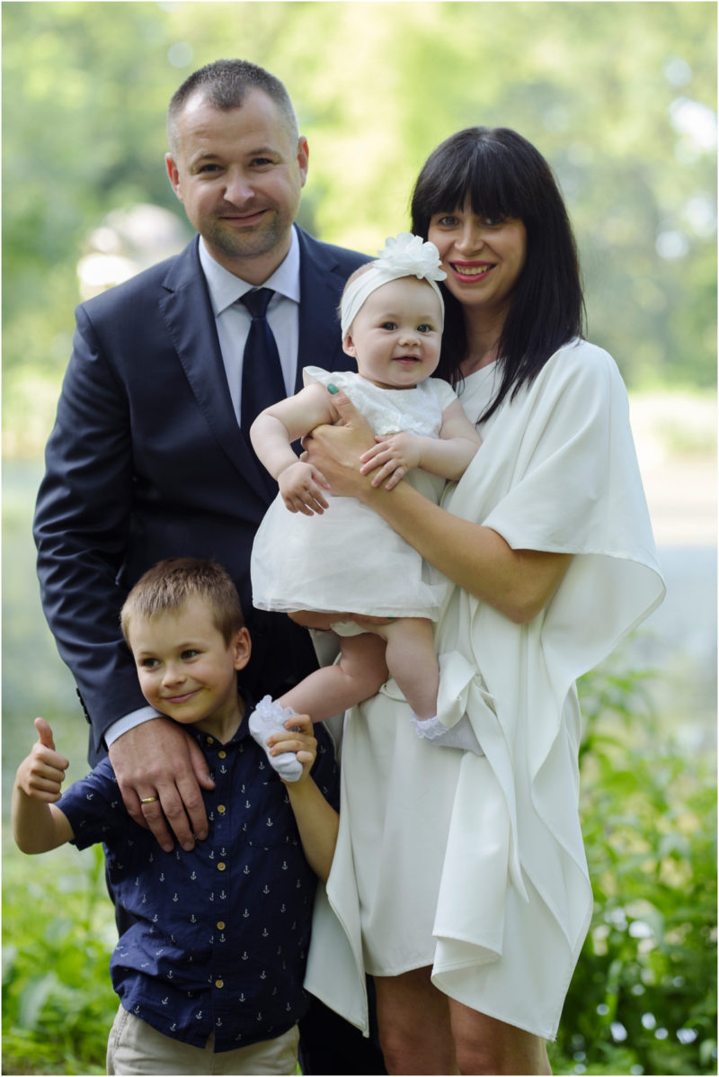 chrzest Wrocław fotografia chrzest Wrocłąw mała dziewczynka siedi na trwaie w parku