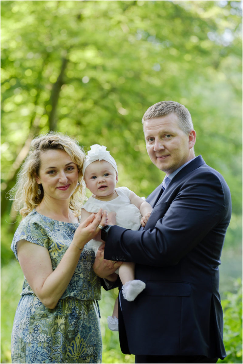 chrzest Wrocław fotografia chrzest Wrocłąw mała dziewczynka siedi na trwaie w parku