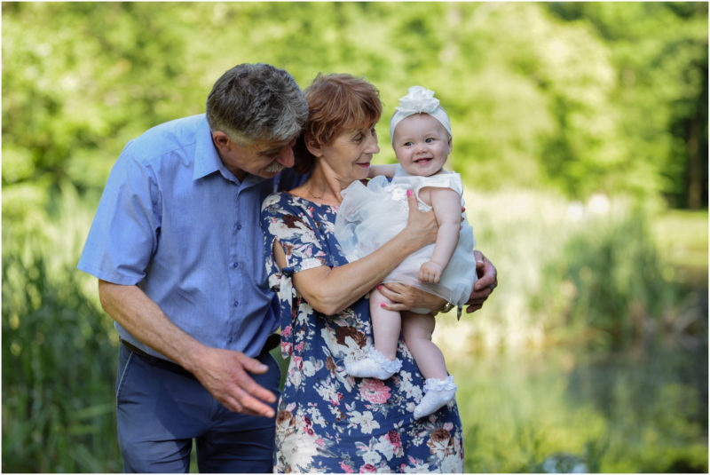 chrzest Wrocław fotografia chrzest Wrocłąw mała dziewczynka siedi na trwaie w parku