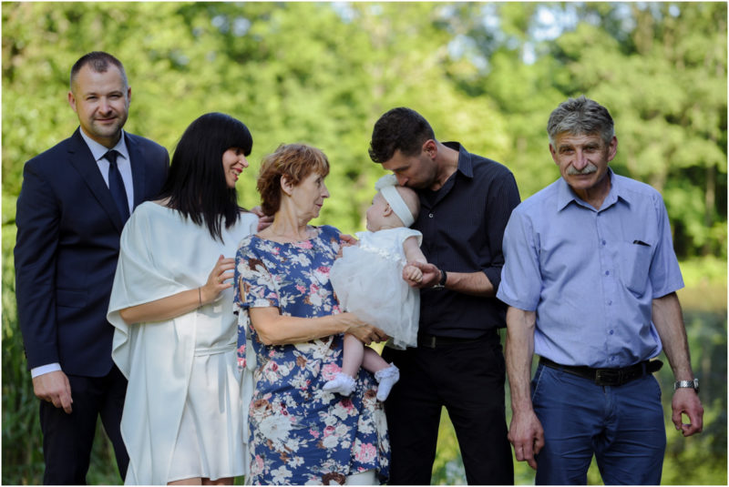 chrzest Wrocław fotografia chrzest Wrocłąw mała dziewczynka siedi na trwaie w parku