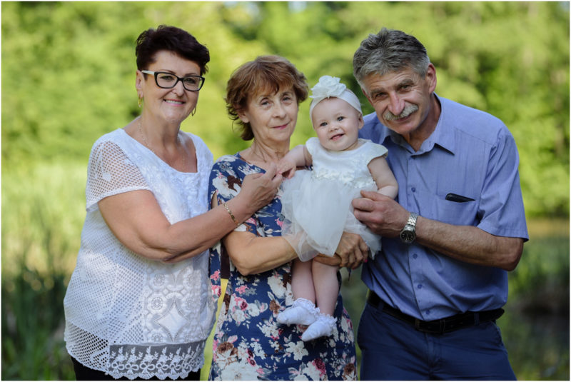 chrzest Wrocław fotografia chrzest Wrocłąw mała dziewczynka siedi na trwaie w parku