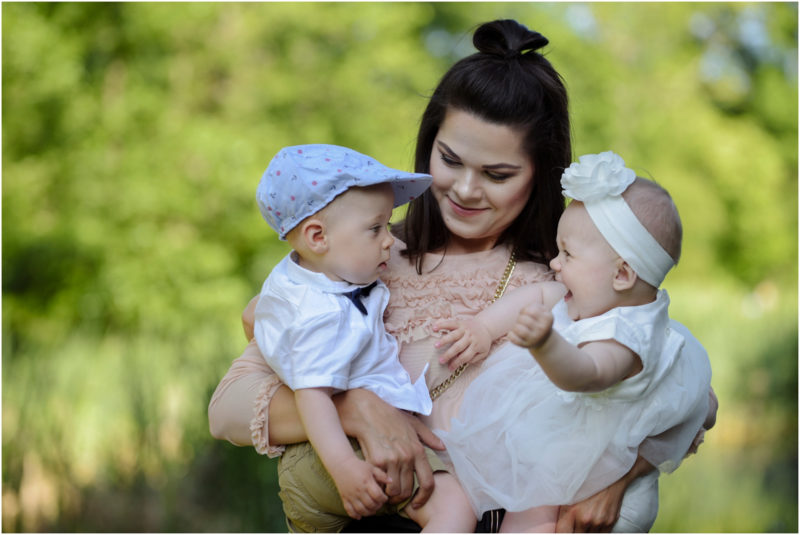 chrzest Wrocław fotografia chrzest Wrocłąw mała dziewczynka siedi na trwaie w parku