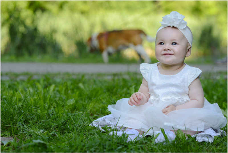 chrzest Wrocław fotografia chrzest Wrocłąw mała dziewczynka siedi na trwaie w parku