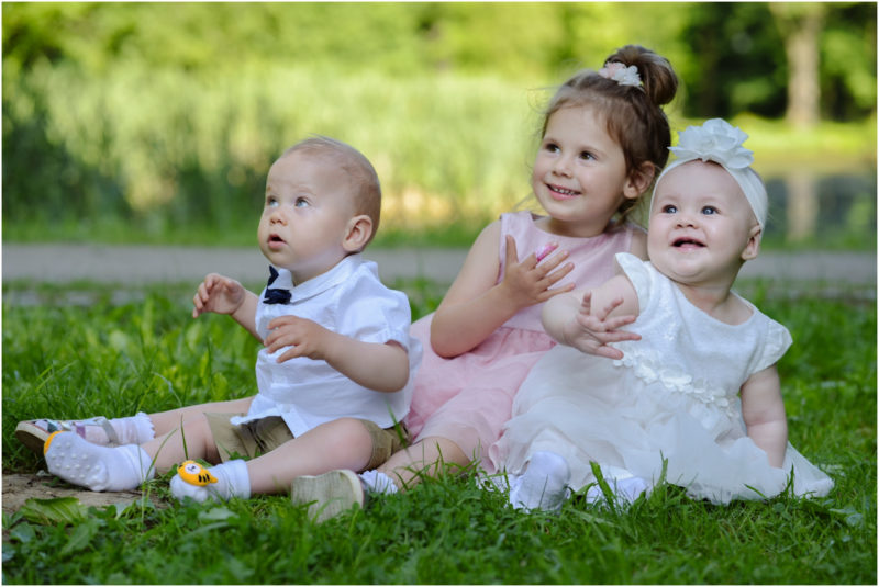 chrzest Wrocław fotografia chrzest Wrocłąw mała dziewczynka siedi na trwaie w parku