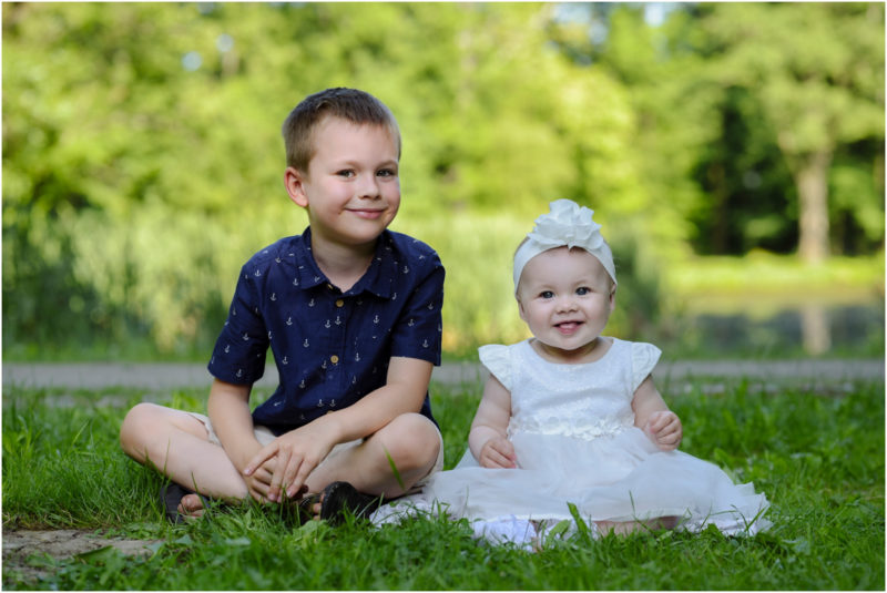 chrzest Wrocław fotografia chrzest Wrocłąw mała dziewczynka siedi na trwaie w parku