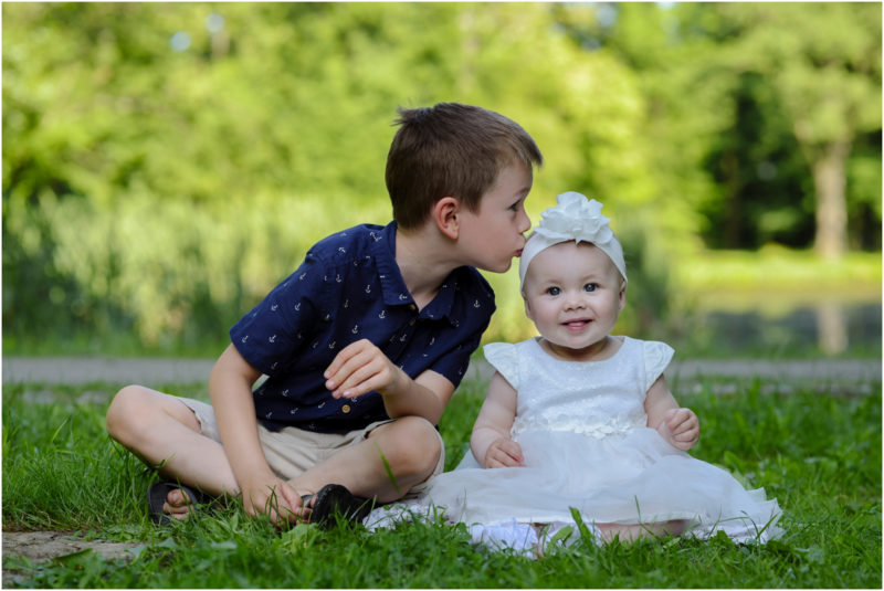 chrzest Wrocław fotografia chrzest Wrocłąw mała dziewczynka siedi na trwaie w parku