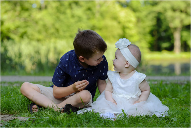 chrzest Wrocław fotografia chrzest Wrocłąw mała dziewczynka siedi na trwaie w parku