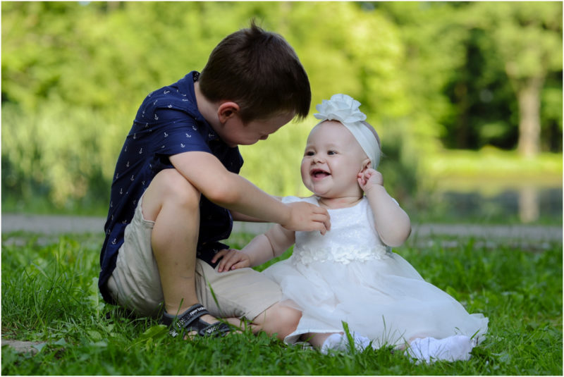 chrzest Wrocław fotografia chrzest Wrocłąw mała dziewczynka siedi na trwaie w parku