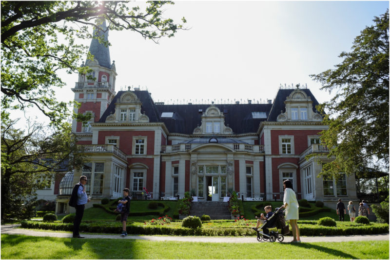 chrzest Wrocław fotografia chrzest Wrocłąw mała dziewczynka siedi na trwaie w parku