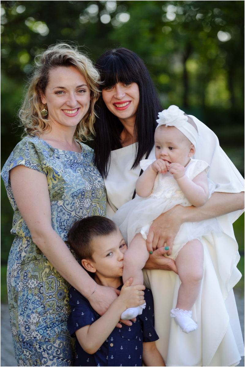 chrzest Wrocław fotografia chrzest Wrocłąw mała dziewczynka siedi na trwaie w parku